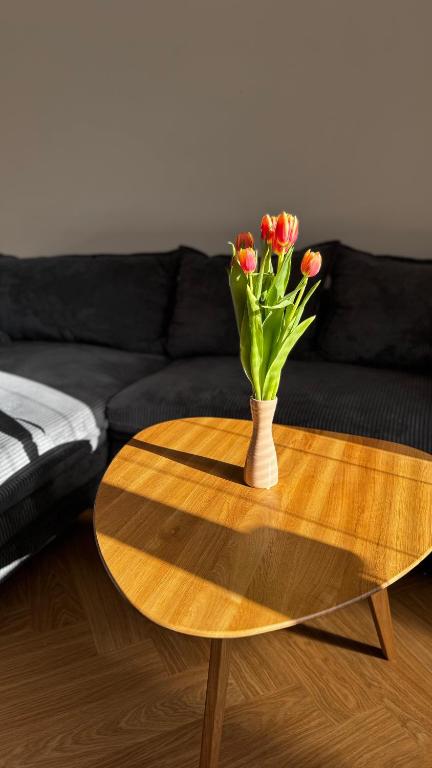 a vase of flowers sitting on a wooden table at apartmán Nataly in Veľký Krtíš