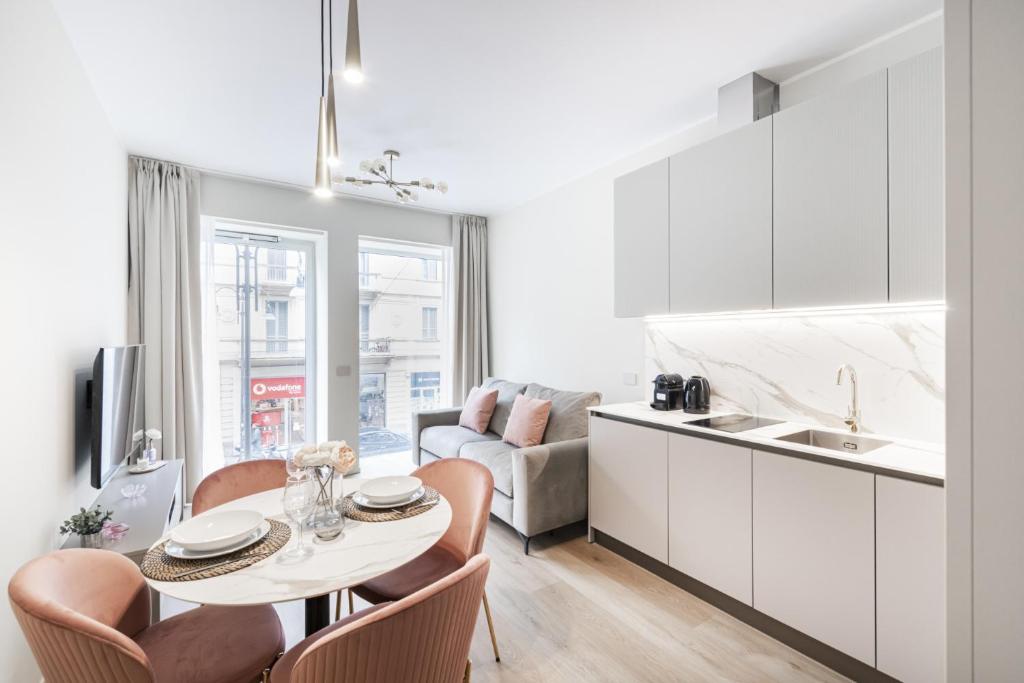 a kitchen and living room with a table and chairs at Easylife - Duomo Deluxe Apartments #5-11 in Milan