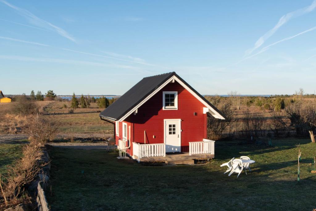 a red house in the middle of a field at Anne's Cottage in Saastna