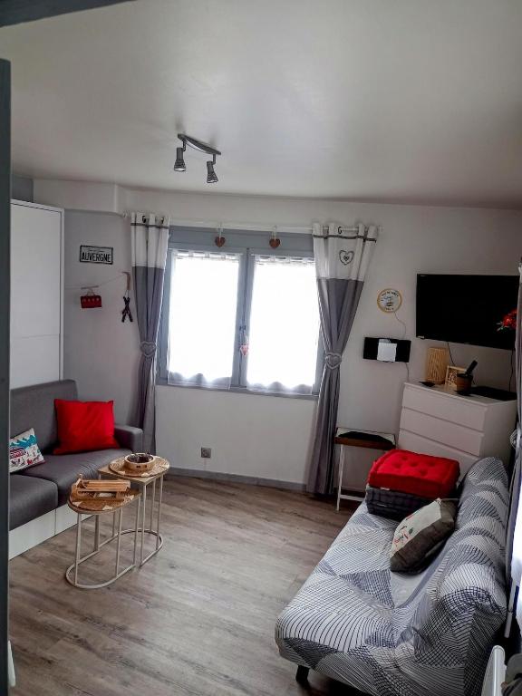 un salon avec un canapé et une table dans l'établissement Appartement hyper centre ville,5pers 'le maloudgja' vue sur le sancy, à Le Mont-Dore