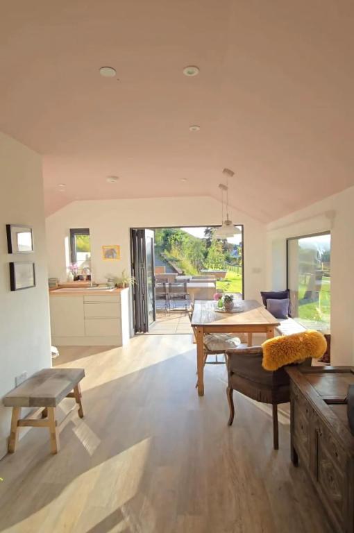 a large living room with a table and a kitchen at The Bw thyn - Ceredigion in Lampeter