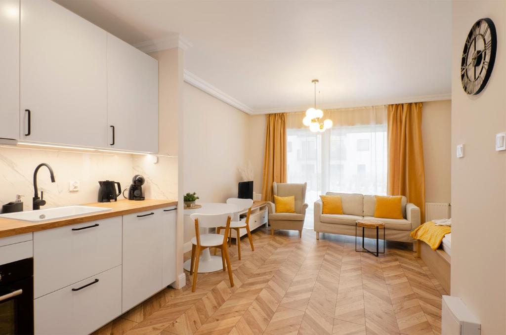 a kitchen and living room with a table and chairs at SKY Home-Sun Apartament -Manufaktura, Bezpłatny Parking, Dostęp na kod in Łódź