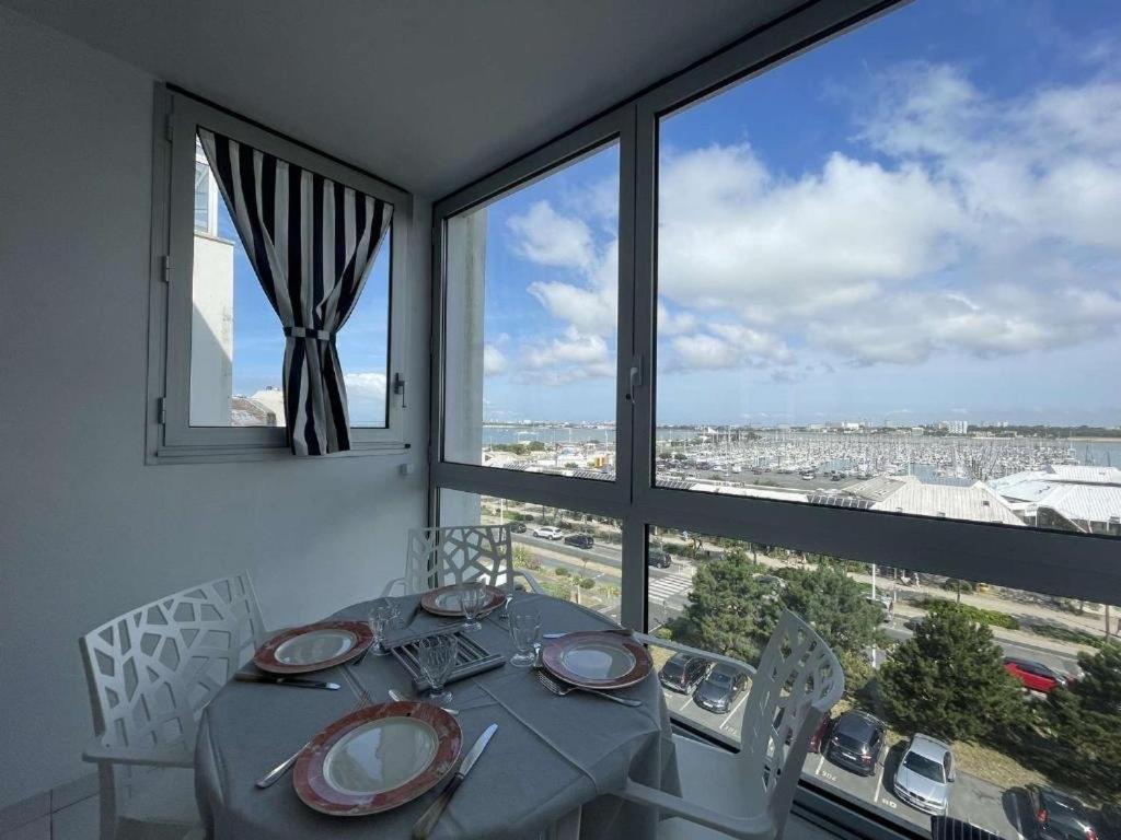 une salle à manger avec une table et une grande fenêtre dans l'établissement Appartement vue mer - LA ROCHELLE - LR240-505, à La Rochelle