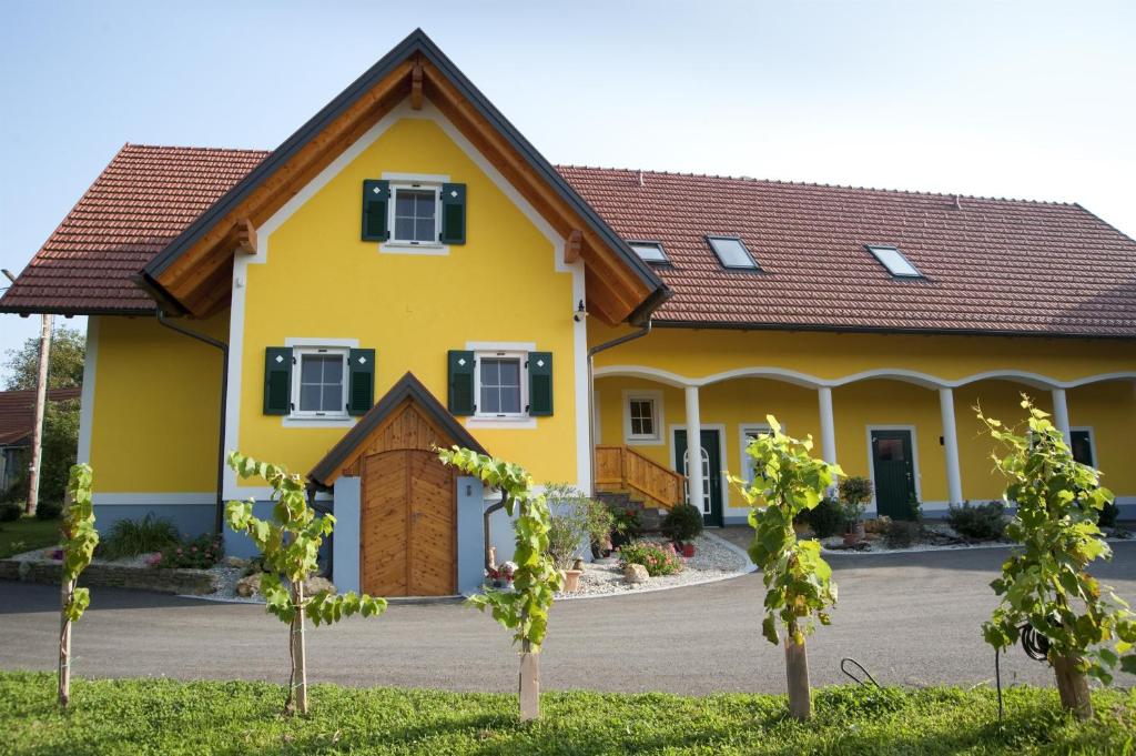 a yellow house with a brown roof at Ferienwohnung Schulter in Leibnitz