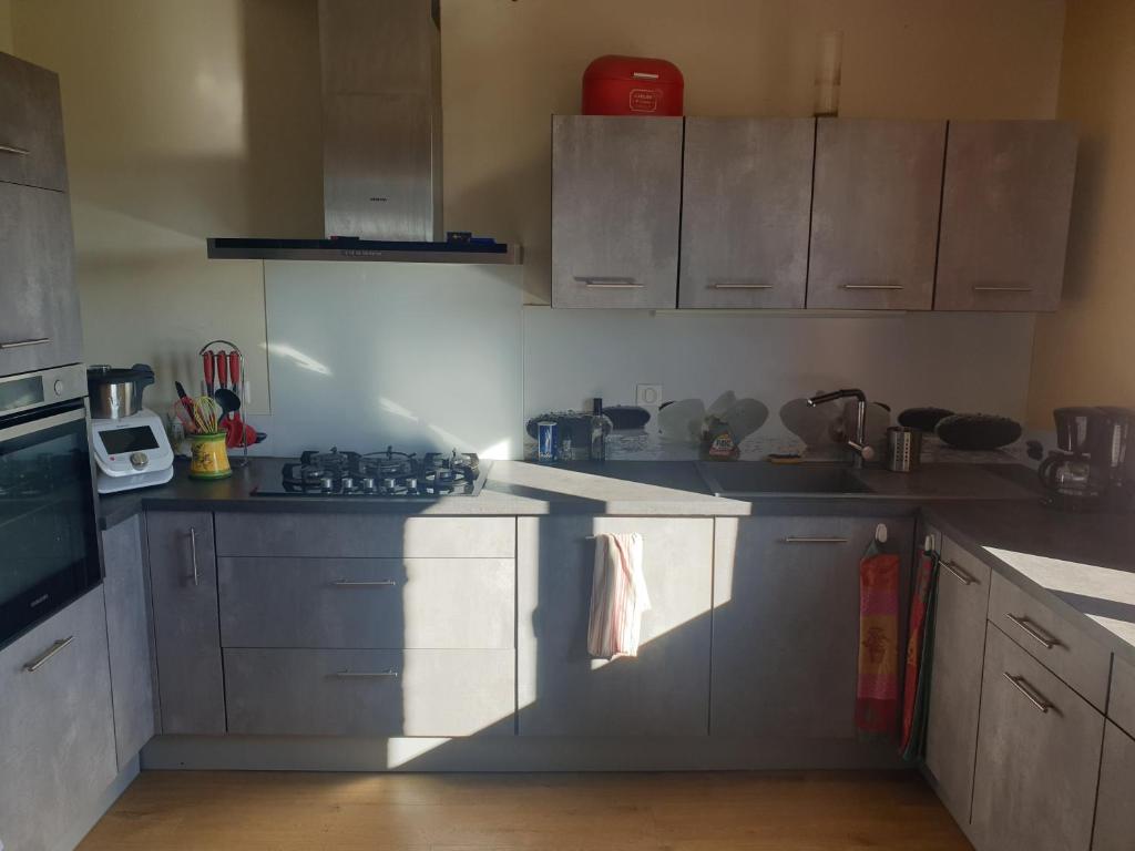 フィジャックにあるChambre au calme avec cuisine équipée en supplément sur demandeの白いキャビネットとコンロ付きオーブンを備えたキッチン