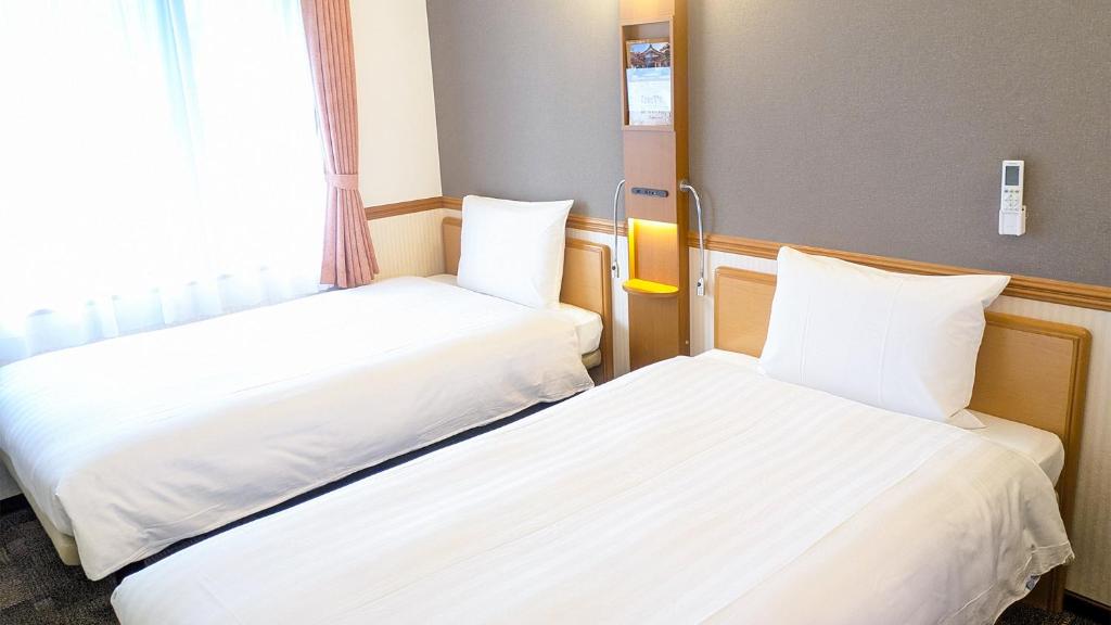 Postel nebo postele na pokoji v ubytování Toyoko Inn Tottori-eki Minami-guchi