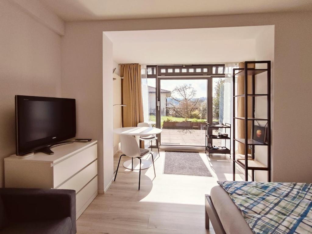 a bedroom with a bed and a television and a desk at Studio near Zurich in Affoltern