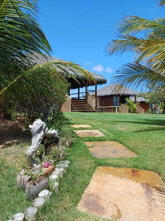 a walkway leading to a resort with a building at Ventos do Delta Kite Chalés in Tutóia