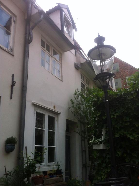 a white house with a street light in front of it at Lübecker Ganghausperle in Lübeck