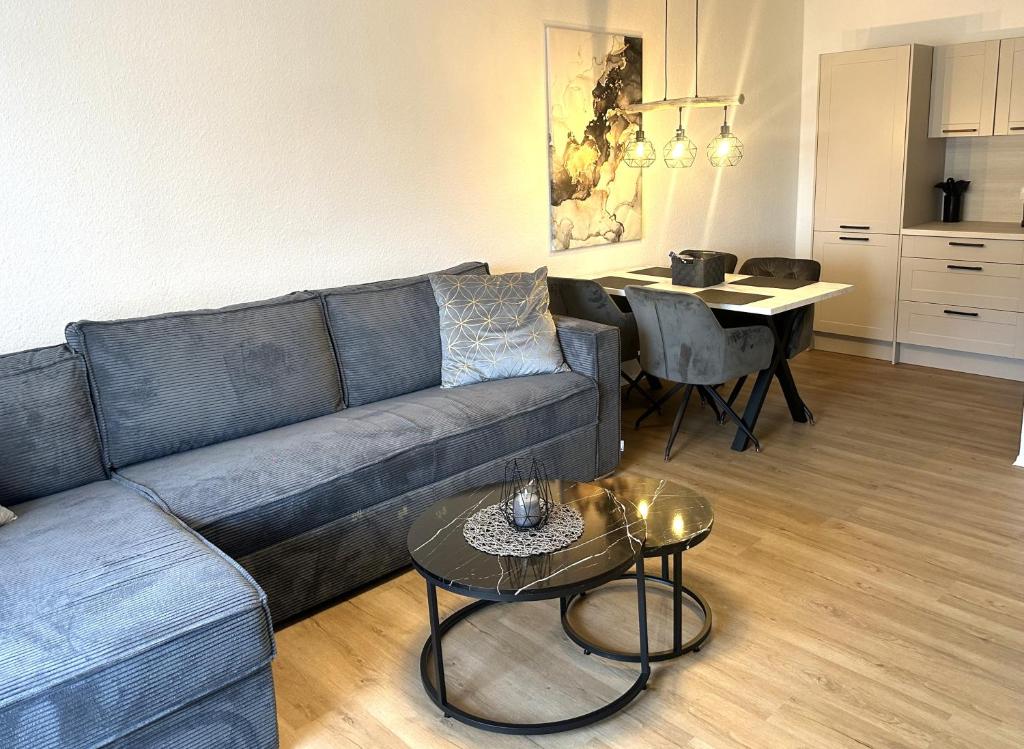 een woonkamer met een bank en een tafel bij Forst & Flair Apartment in Bad Harzburg