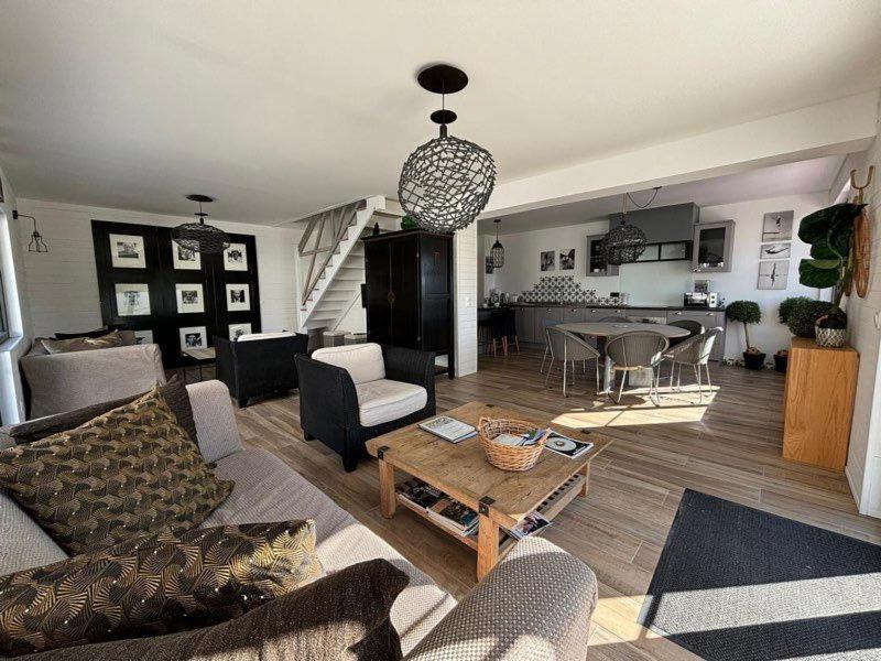 un salon avec un canapé et une table dans l'établissement L'Atelier d'artiste by Domaine de Colomban - plages et commerces à pieds, à Carnac