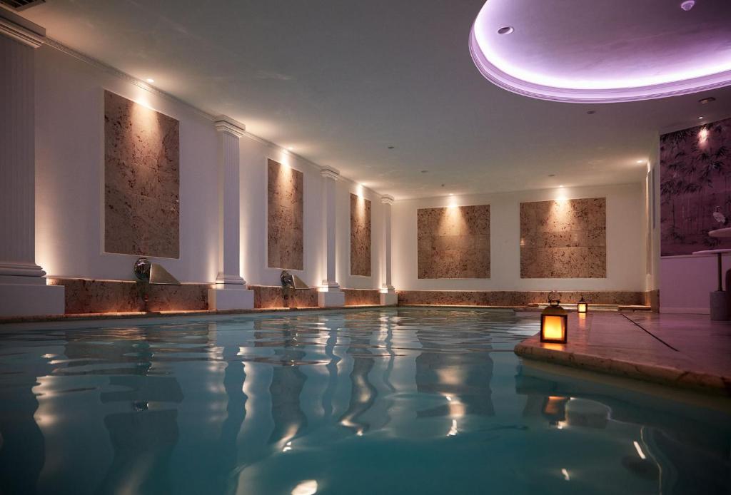 une piscine dans un hôtel avec un plafond dans l'établissement Paris j'Adore Hotel & Spa, à Paris