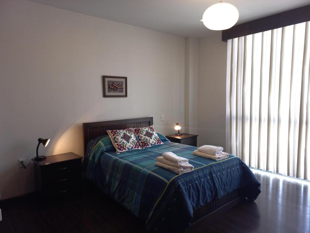 een slaapkamer met een bed met handdoeken erop bij Habitaciones en alquiler centro de Tarija in Tarija