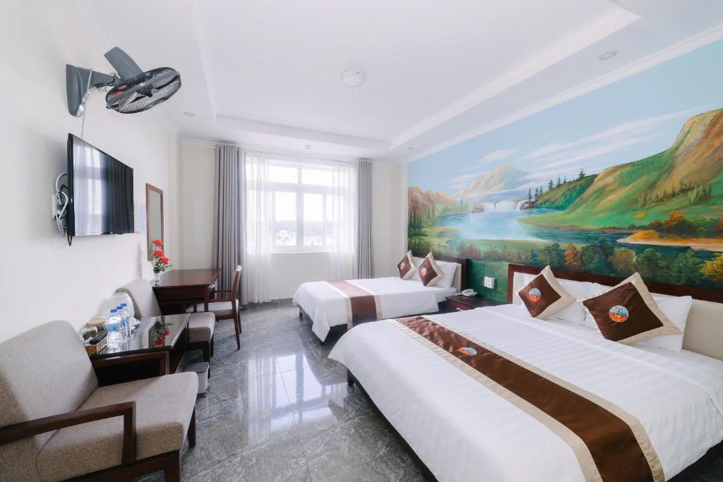 a hotel room with two beds and a painting at Đoàn An điều dưỡng 198 in Xuan An