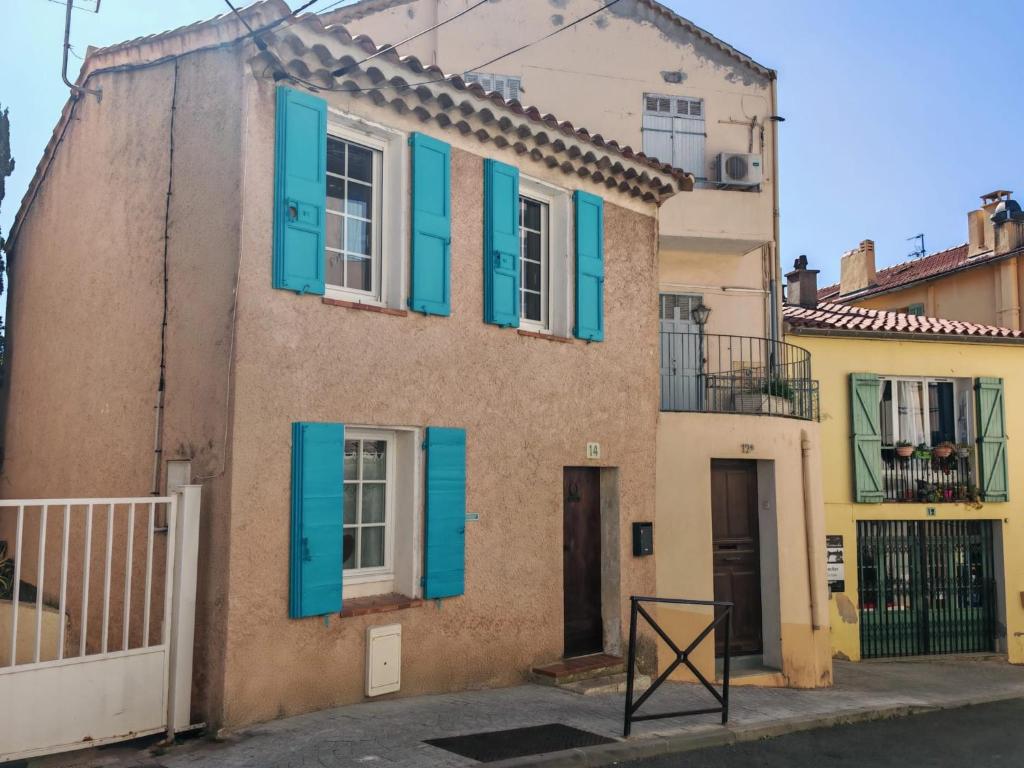 une maison avec volets bleus dans une rue dans l'établissement La maison aux volets bleus, à Bandol