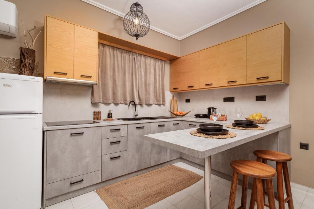 una cucina con elettrodomestici in acciaio inossidabile e mobili in legno di Koklas Studios a Lithakia