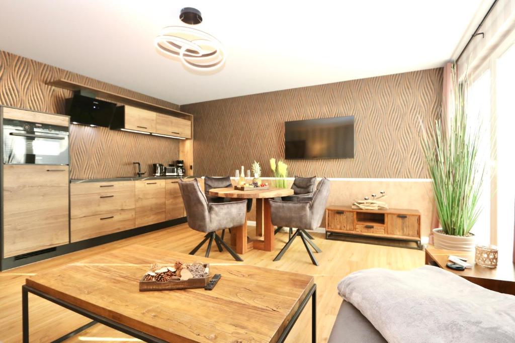 una cucina e un soggiorno con tavolo e sedie di Appartement Leuchtfeuer Ostseenordsterne a Warnemünde