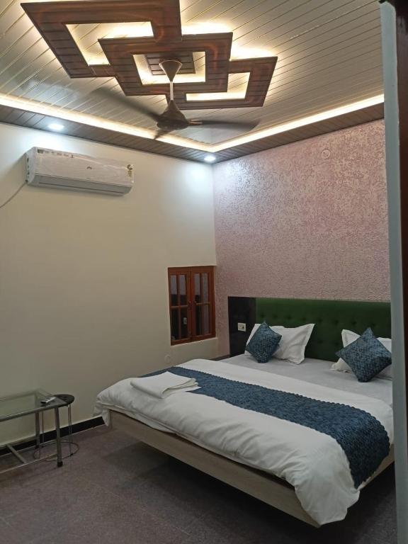 a bedroom with a large bed with a ceiling at Snerola family hotel in Bhauli