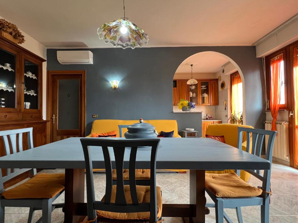 a kitchen and dining room with a table and chairs at La Casa di Luci in Rosia