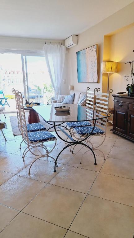 un salon avec une table, des chaises et un canapé dans l'établissement Appartement 2 chambres terrasse 100m Croisette, à Cannes