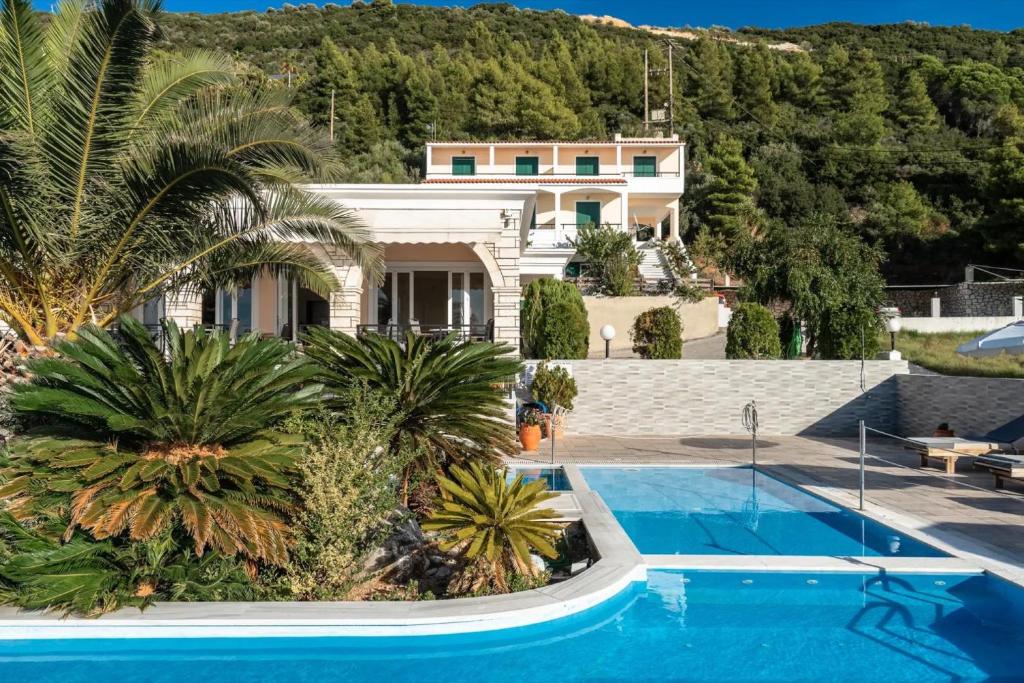 a villa with a swimming pool and a house at Sunset Premium Studio 12 in Agios Nikitas