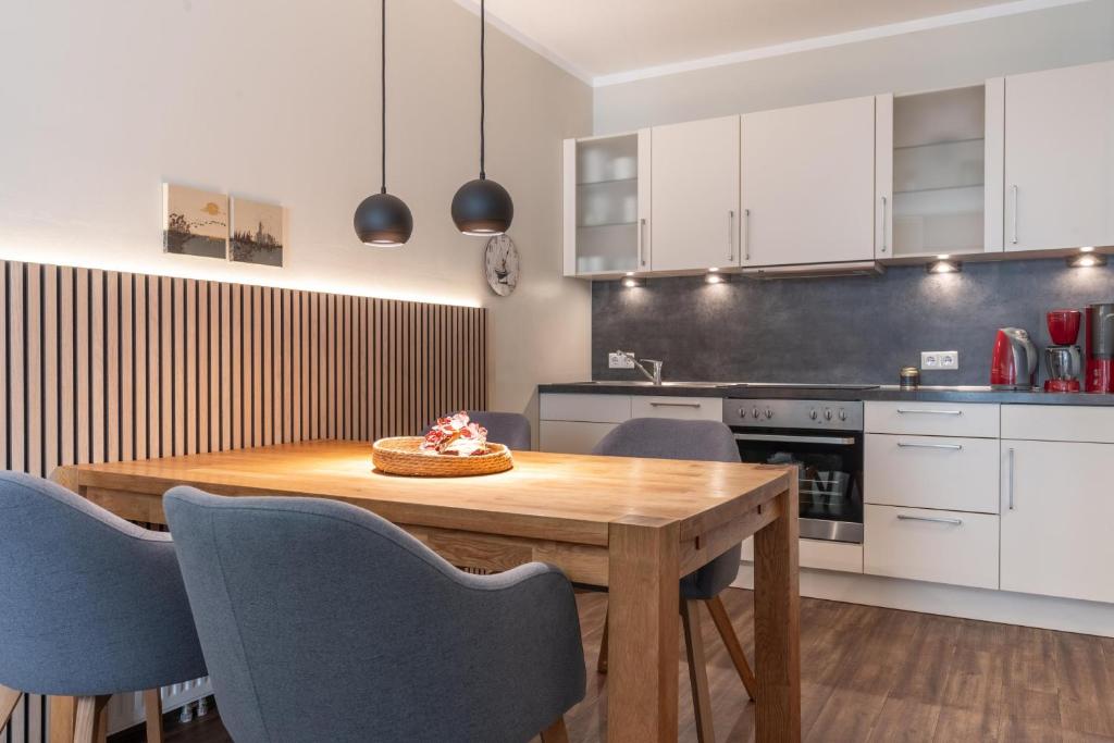 a kitchen with a wooden table and blue chairs at Rodehuus Wohnung 6 in Borkum