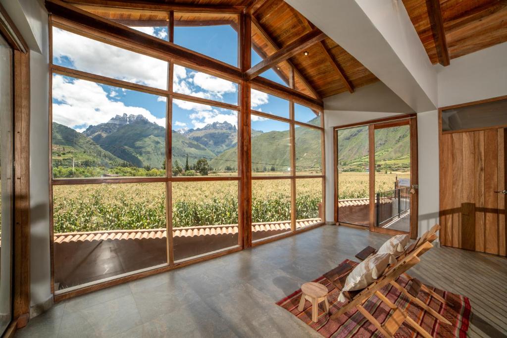 a room with a large window with a view of a field at New Charming Countryside Haven Sacred Valley in Huaran