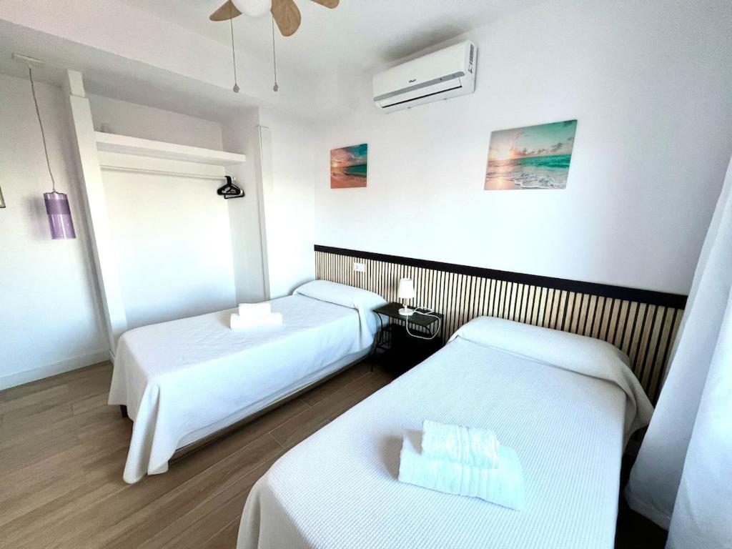 a hotel room with two beds and a window at Apartamento Velázquez Aeropuerto B in Málaga