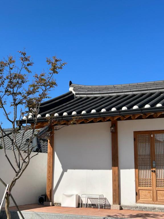 a white building with a bench in front of it at Yeomok Stay in Gyeongju