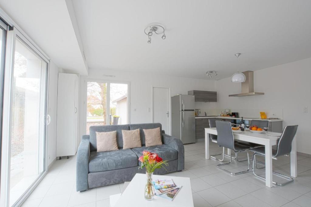 un salon avec un canapé et une table dans l'établissement Les Fougères maison tout confort 4 personnes, à Andernos-les-Bains