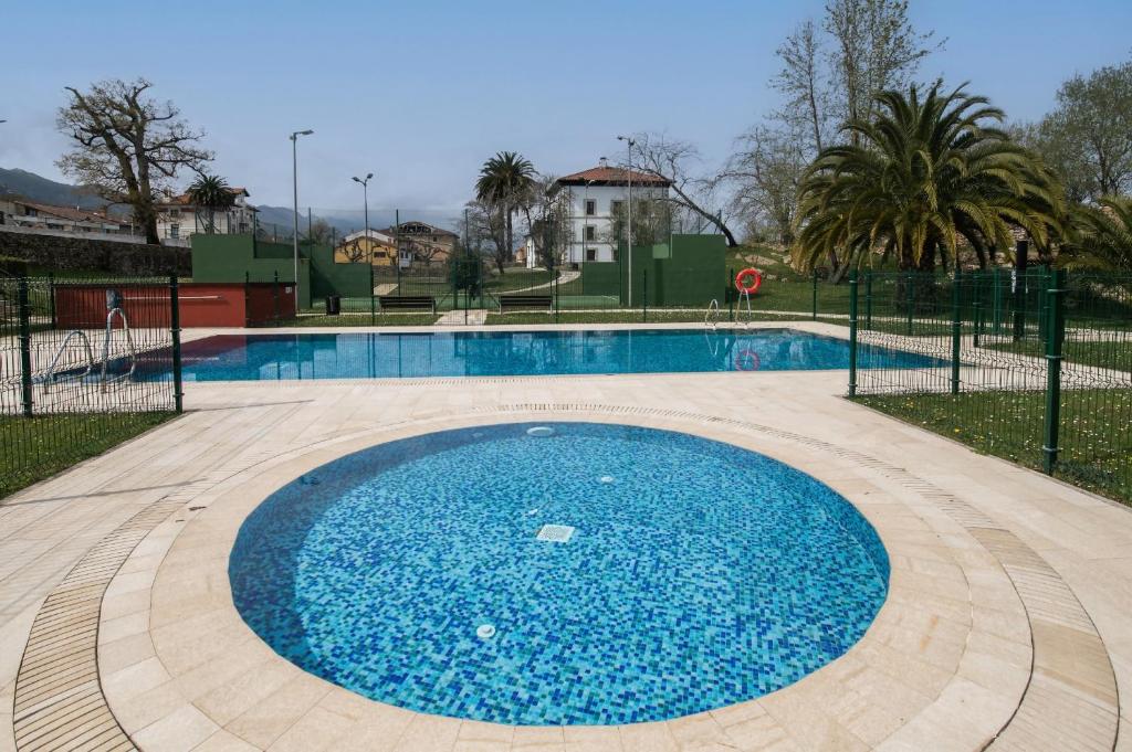 a swimming pool with blue water in a park at Apartamento Tejasturias in Noriega