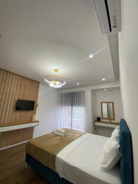 Un dormitorio con una cama grande y un televisor. en Morea Residence, en Ulcinj