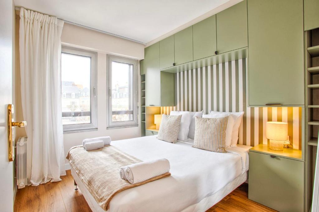 une chambre avec un grand lit blanc avec deux serviettes dessus dans l'établissement Le Morny Palace - 2P - Place Morny - DEAUVILLE, à Deauville