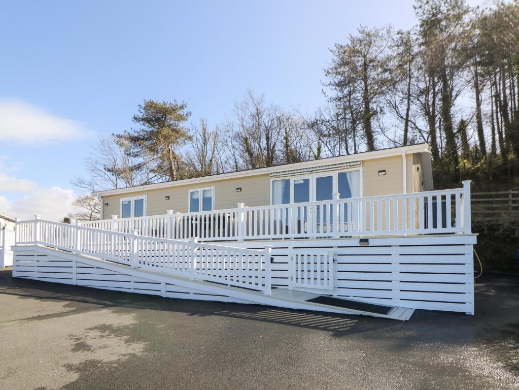 a mobile home with a large white porch at McAuliffe Lodge in Borth