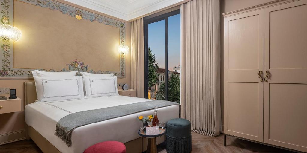 une chambre avec un lit et une grande fenêtre dans l'établissement Komana Hotel Binbirdirek, à Istanbul