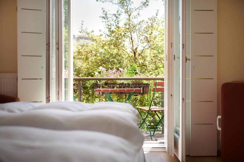 a bedroom with an open door to a balcony with a table at Hotel Weitzer Graz - Centre of Graz in Graz