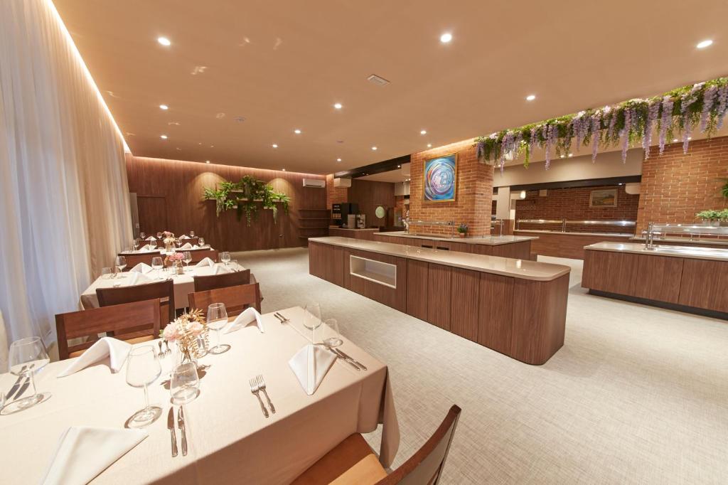 a restaurant with white tables and chairs at Villas - Hotel & Resort Adria Ankaran in Ankaran