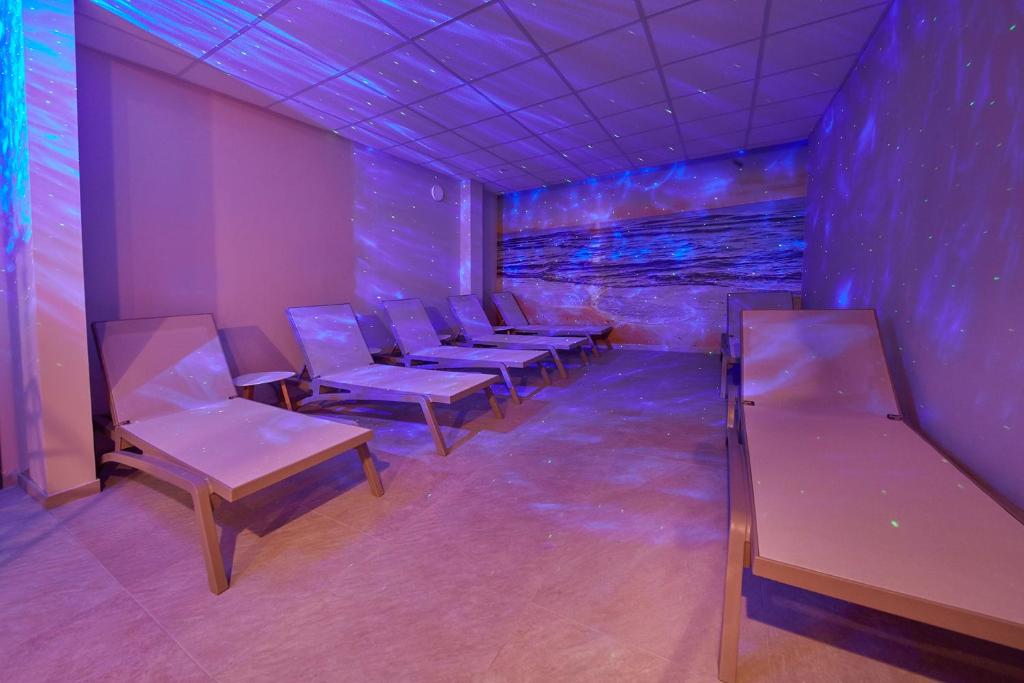 a row of chairs in a room with purple lights at Villas - Hotel & Resort Adria Ankaran in Ankaran