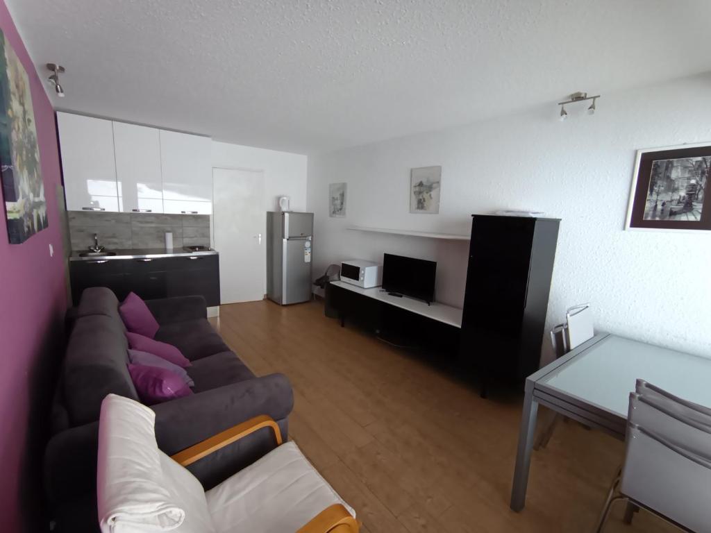 un salon avec un canapé et une table dans l'établissement Studio + Coin Montagne - 2* - 4 Pers. - Village - Terrasse Privée - Animaux Acceptés - FR-1-445-25, à Montgenèvre