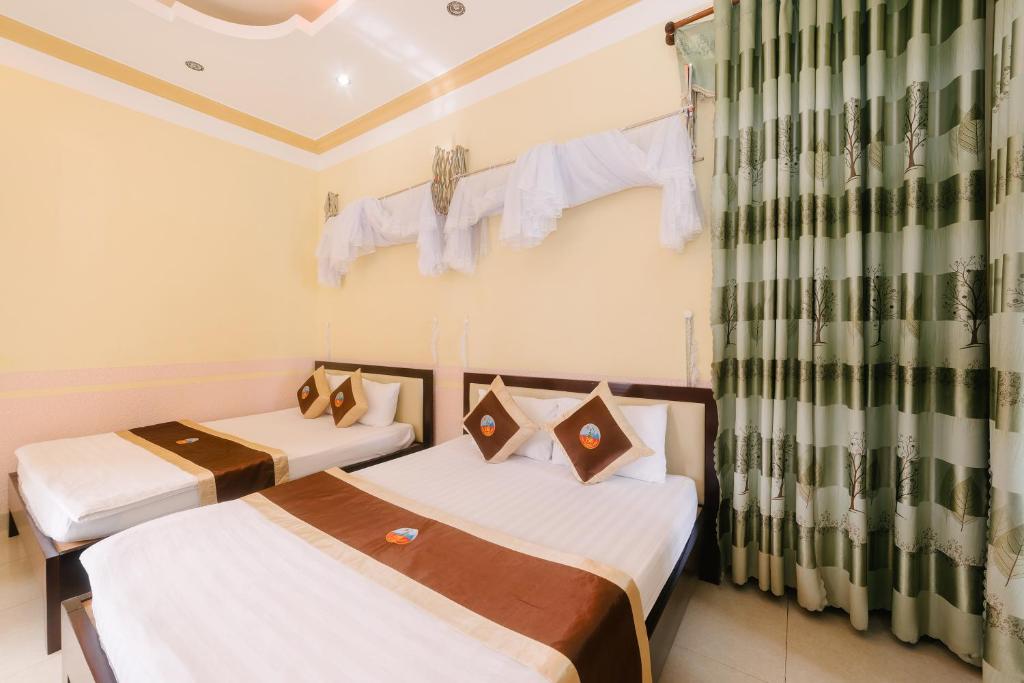 two beds in a small room with curtains at Đoàn An điều dưỡng 198 in Khu Chi Lăng