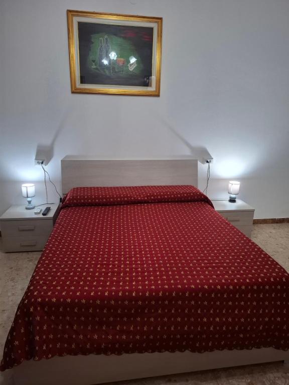 a bedroom with a bed with a red comforter at Lucazione Turistica in Mestre