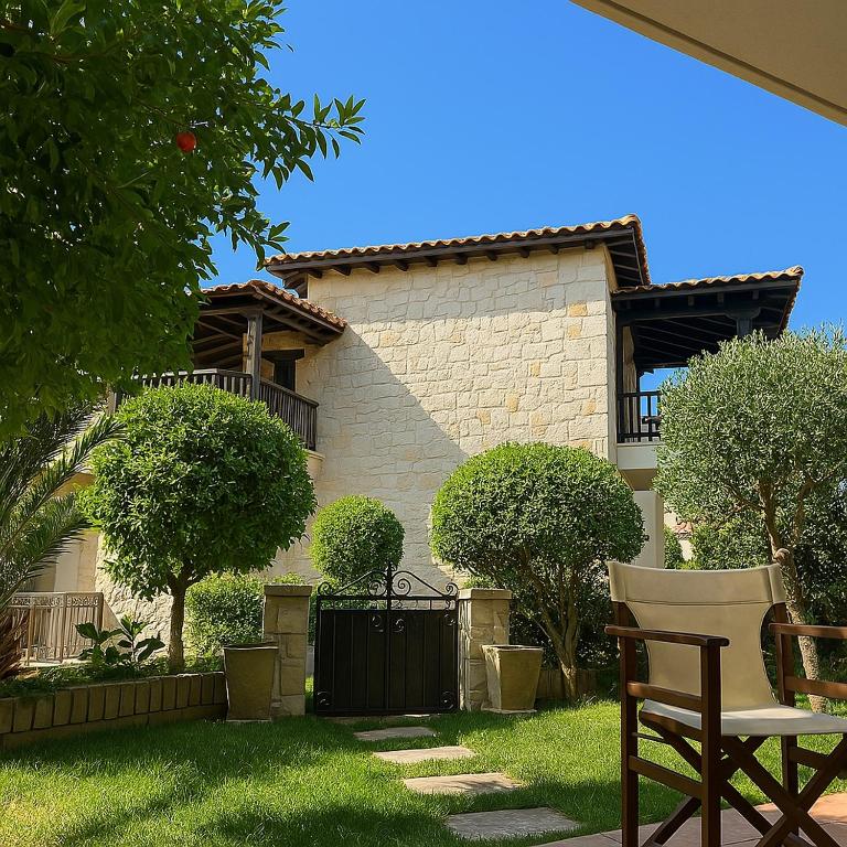 a house with a chair in front of a yard at Sea and Stone Villa in Afitos