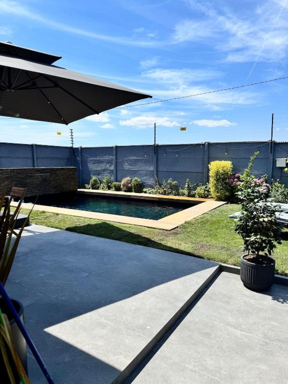 a backyard with a swimming pool and an umbrella at Moderna casa con piscina e internet de alta velocidad en Talca in Talca
