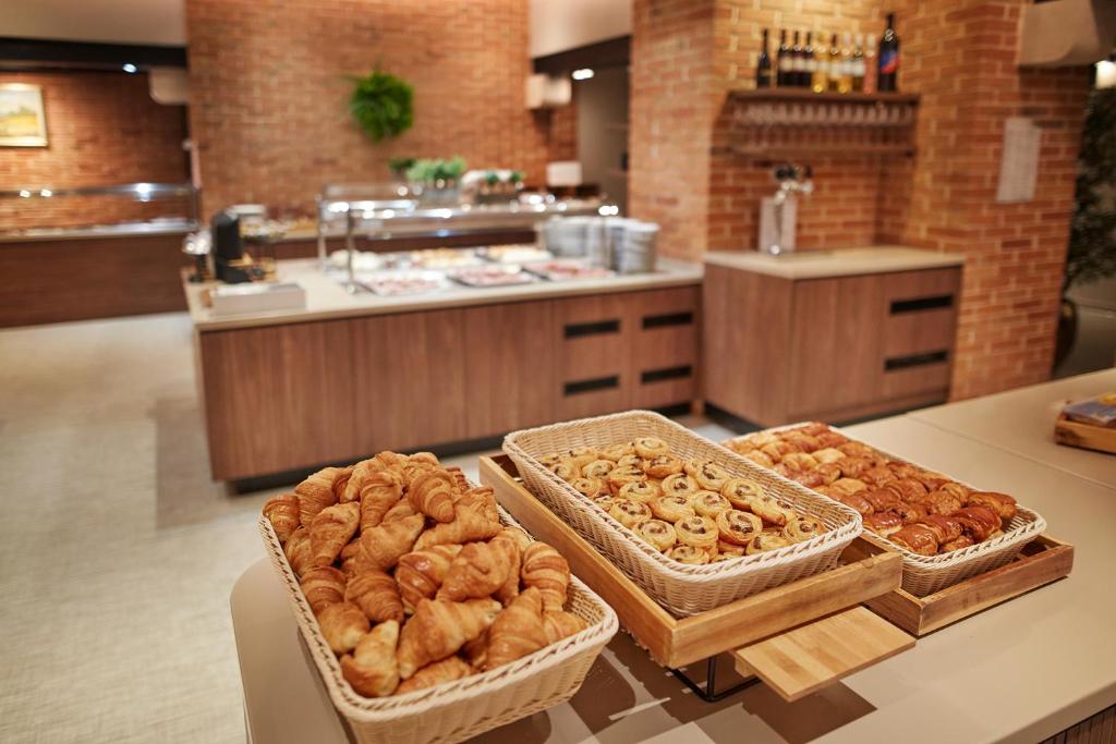 a bakery with three baskets of pastries on a counter at Olive Family Suites - Hotel & Resort Adria Ankaran in Ankaran