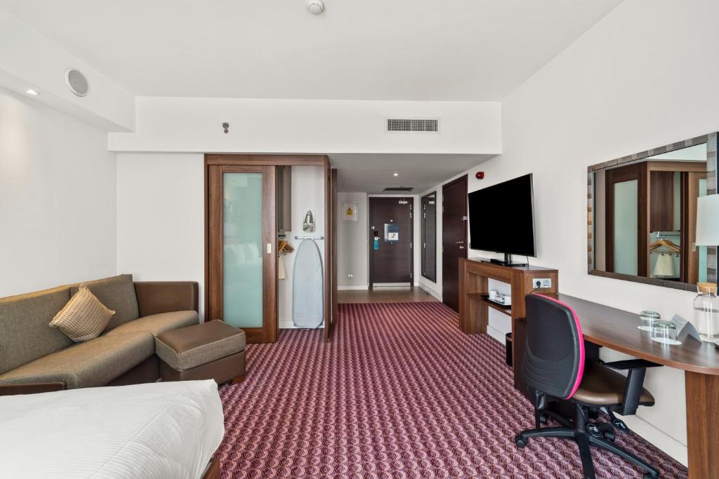 a hotel room with a bed and a desk at Hampton by Hilton Cluj-Napoca in Cluj-Napoca