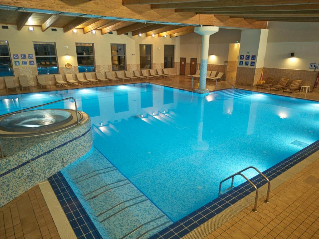 a large pool with blue water in a hotel at Olive Family Suites - Hotel & Resort Adria Ankaran in Ankaran