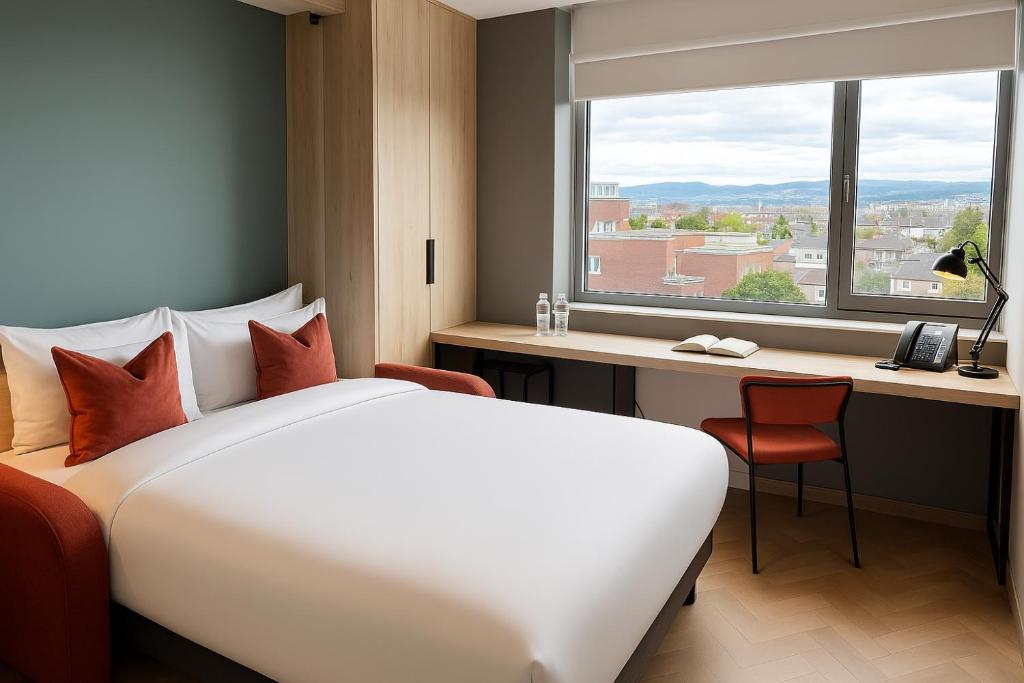 a hotel room with a bed and a desk and a window at Niche Living - Dun Laoghaire in Dublin