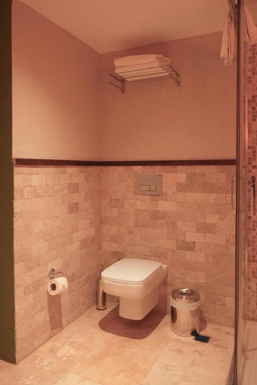 a bathroom with a toilet in a brick wall at Phellos Suites Boutique Hotel in Şile