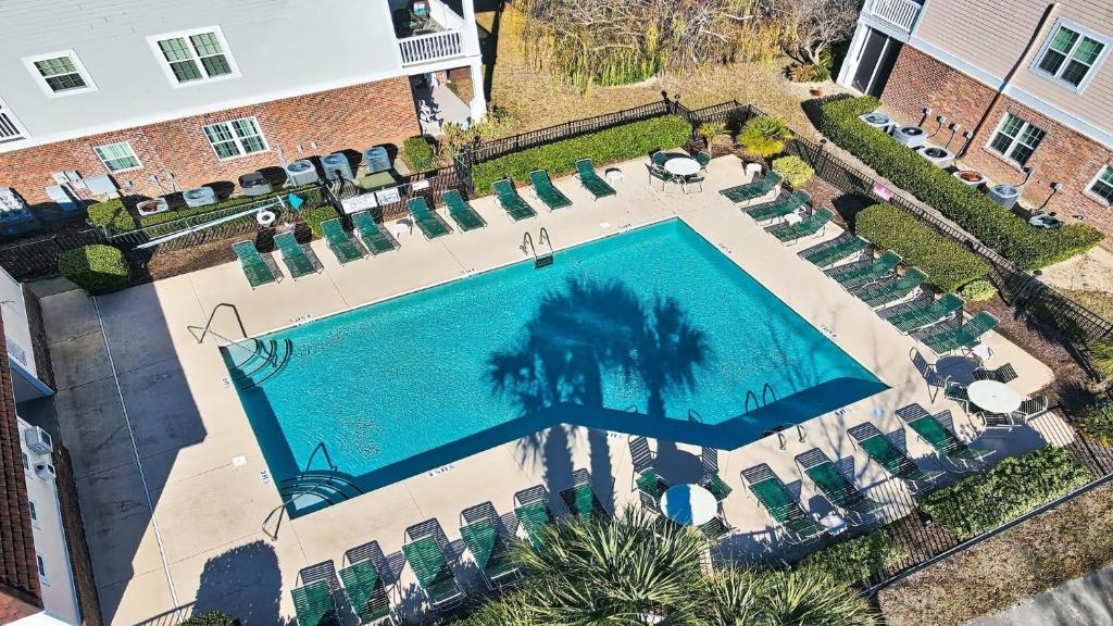 an overhead view of a swimming pool with chairs and a building at 422 Cypress Bend Condo in North Myrtle Beach