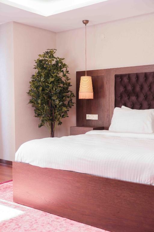 a bedroom with a large bed and a potted plant at Phellos Suites Boutique Hotel in Şile